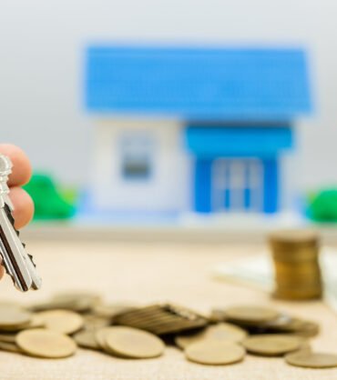 Keys and money piles and houses for mortgage loan concepts.