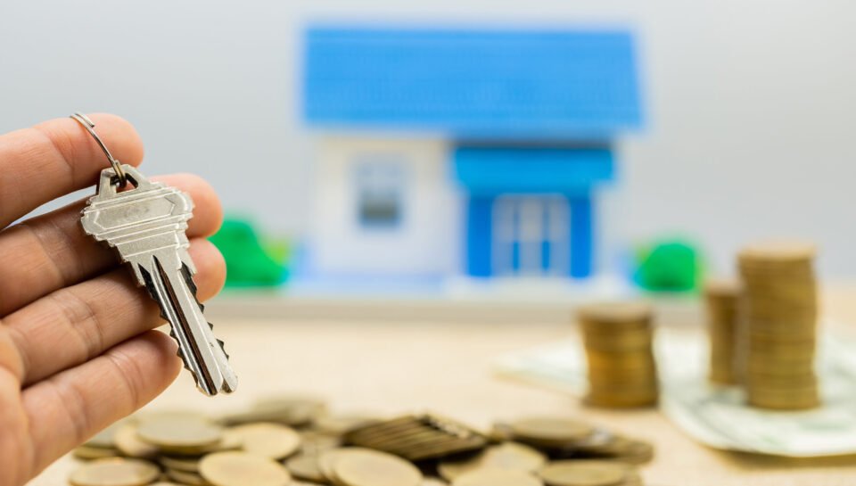 Keys and money piles and houses for mortgage loan concepts.